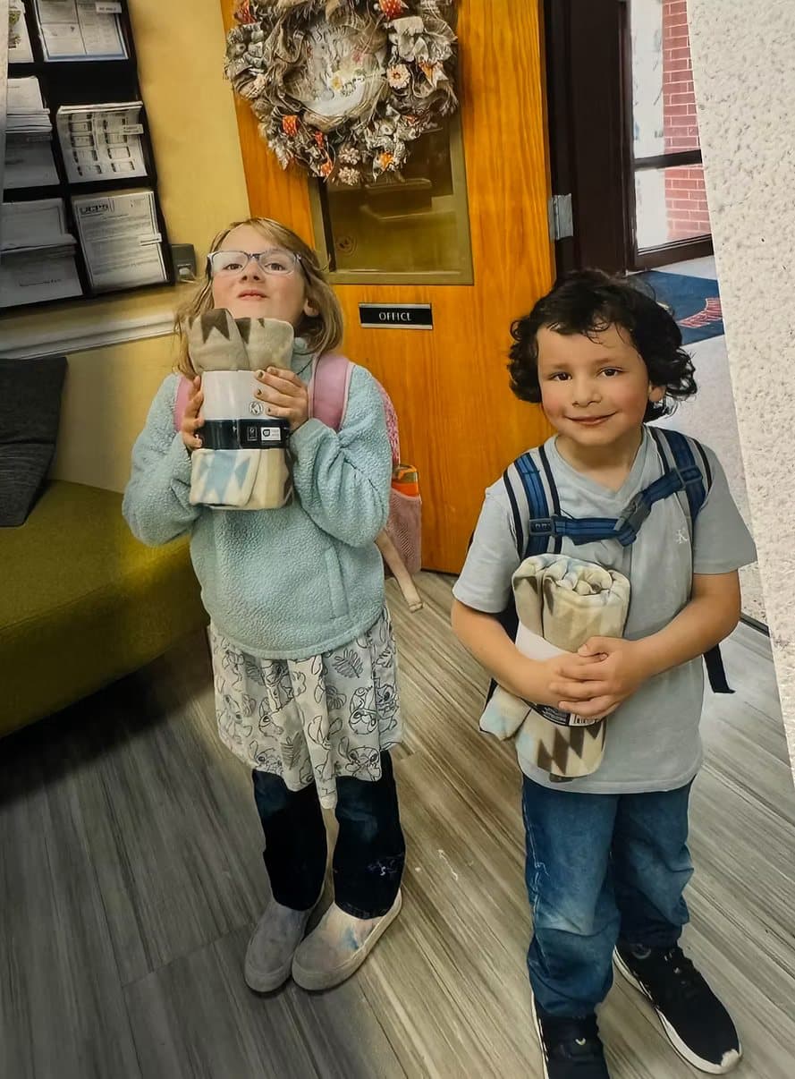 Two students holding their new winter blankets